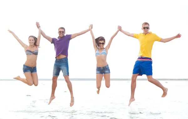 Grupo de amigos ou casais pulando na praia — Fotografia de Stock