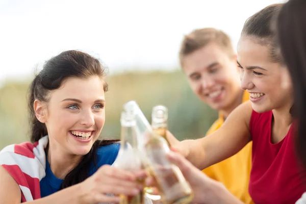 Women and men with drinks on the beach — Stock Photo, Image