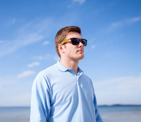 Man in sunglasses on the beach Stock Picture