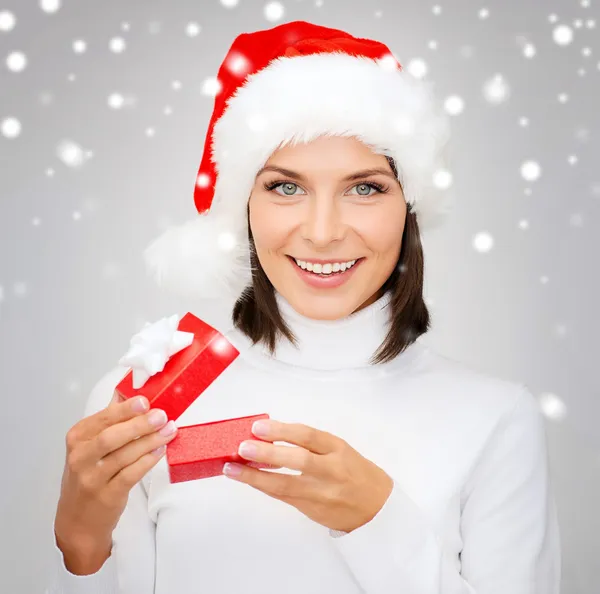 Lachende vrouw in Kerstman hoed met kleine geschenkverpakking — Stockfoto