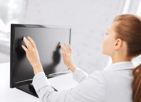 Улыбающаяся деловая женщина с сенсорным экраном в офисе — стоковое фото