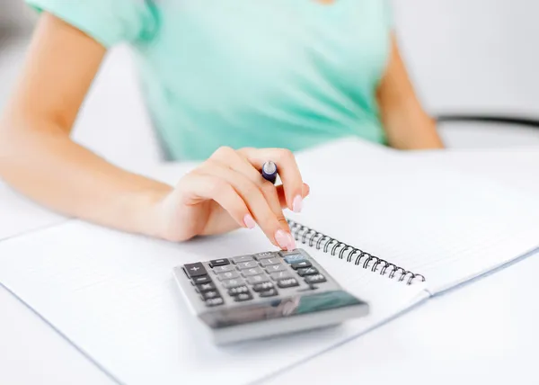 Geschäftsfrau arbeitet mit Taschenrechner im Büro — Stockfoto