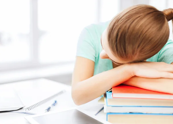 Estudante cansado dormindo em estoque de livros — Fotografia de Stock