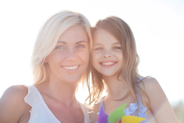 Gelukkig moeder en kind meisje met pinwheel speelgoed — Stockfoto