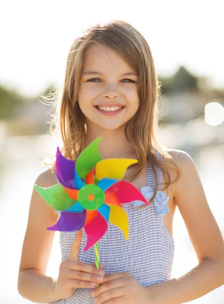 Menina feliz com brinquedo pinwheel colorido — Fotografia de Stock