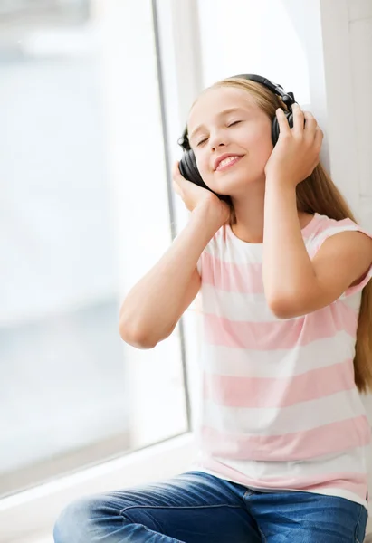 Little girl with headphones at home — Zdjęcie stockowe