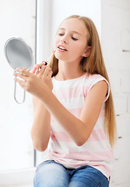 Tonårsflicka med läppglans och spegel — Stockfoto
