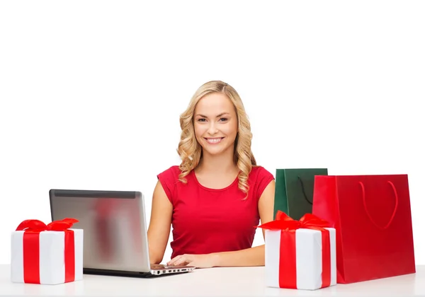 Donna con scatole regalo, borse e computer portatile — Foto Stock