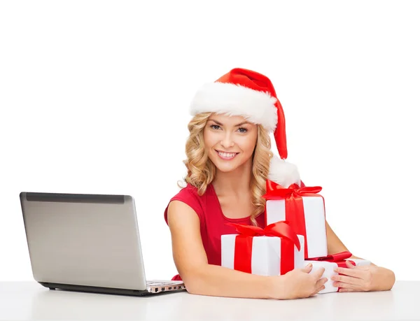 Woman with gift boxes and laptop computer — Stock Photo, Image