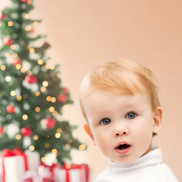 Glad liten pojke med julgran och gåvor — Stockfoto