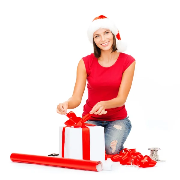 Mujer sonriente en sombrero de ayudante de santa con caja de regalo — Foto de Stock