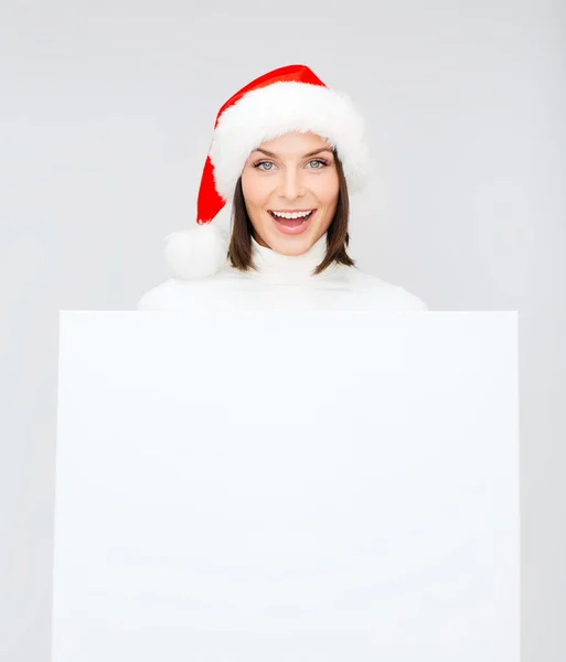 Vrouw in helper kerstmuts met een leeg wit bord — Stockfoto