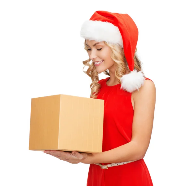 Усміхнена жінка в капелюсі Санта помічника з подарунковою коробкою — стокове фото