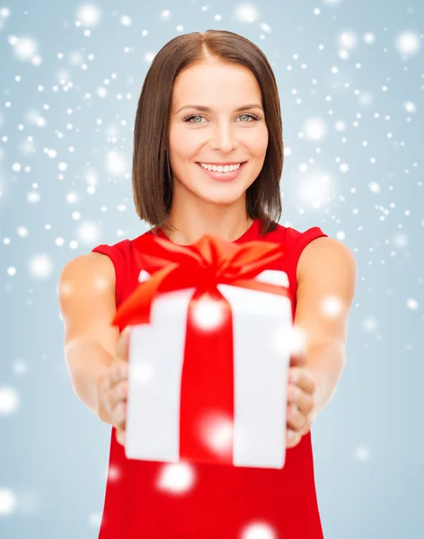 Smiling woman in red dress with gift box — Stock Photo, Image