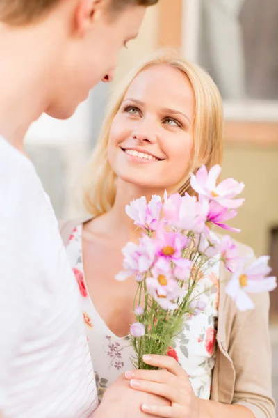 Couple avec des fleurs dans la ville — Photo