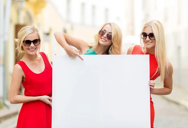 Drei glückliche blonde Frauen mit leerem weißen Brett — Stockfoto