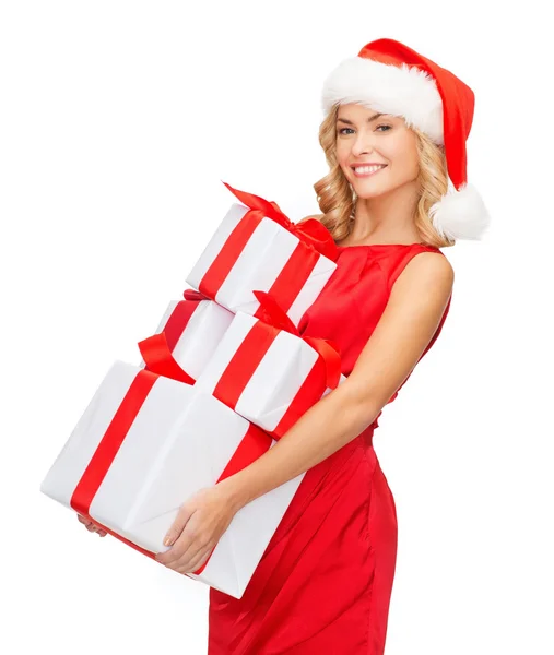 Frau mit Weihnachtsmann-Helfermütze mit vielen Geschenkboxen — Stockfoto