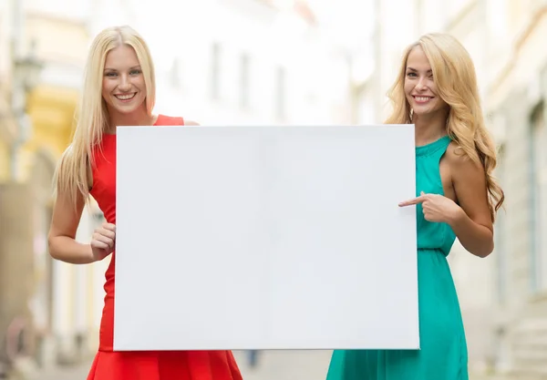 Two happy blonde women with blank white board Royalty Free Stock Photos