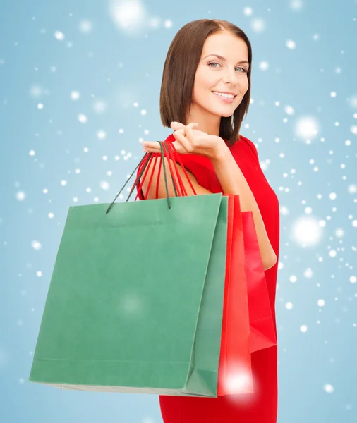 Mulher em vestido vermelho com sacos de compras — Fotografia de Stock