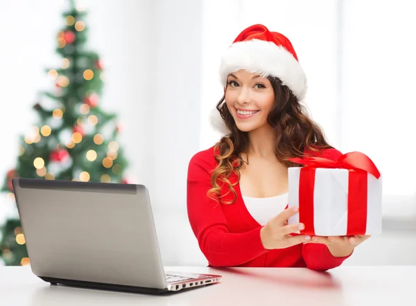 Woman with gift box and laptop computer — Stock Photo, Image