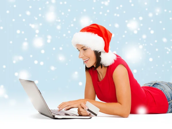 Femme en santa chapeau avec ordinateur portable et carte de crédit — Photo