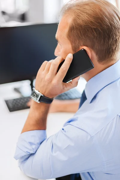 Zakenman met smartphone in office — Stockfoto