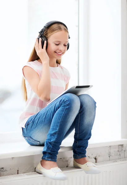Girl with tablet pc and headphones at home Royalty Free Stock Photos