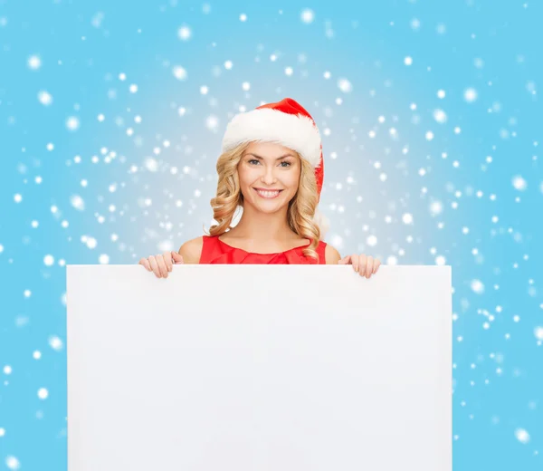 Žena v pomocníka čepice santa s prázdnou bílou tabuli — Stock fotografie