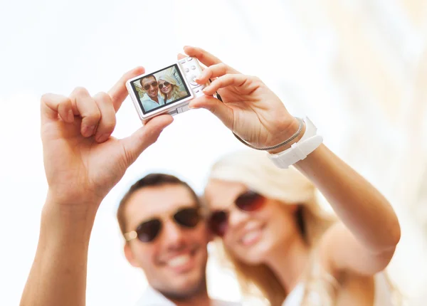 Casal viajante tirando foto com câmera — Fotografia de Stock