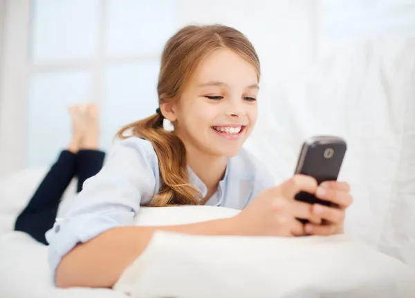 Menina com smartphone em casa — Fotografia de Stock