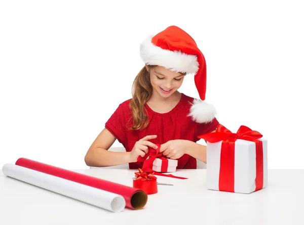 Chica sonriente en sombrero de ayudante de santa con caja de regalo —  Fotos de Stock