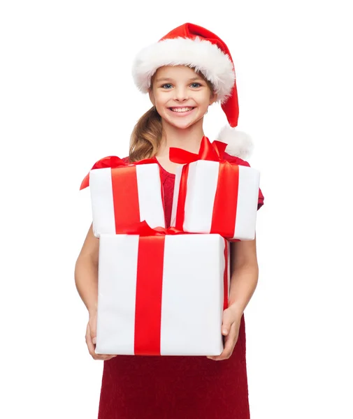 Chica en sombrero de ayudante de santa con muchas cajas de regalo — Foto de Stock