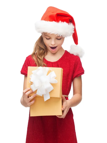 Chica sonriente en sombrero de ayudante de santa con caja de regalo —  Fotos de Stock