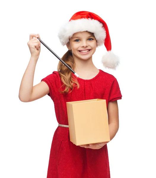 Chica sonriente en sombrero de ayudante de santa con caja de regalo — Foto de Stock