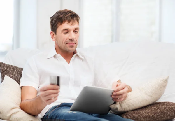 Man with tablet pc and credit card at home — Stock Photo, Image