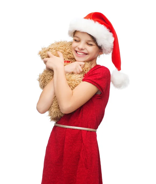 Smiling girl in santa helper hat with teddy bear Royalty Free Stock Photos