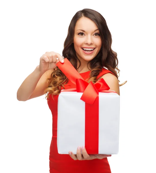 Mujer sonriente en vestido rojo con caja de regalo — Foto de Stock