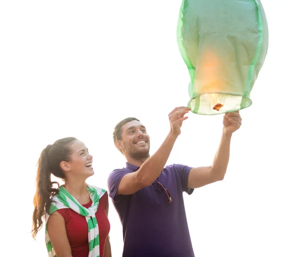 Paar mit chinesischen Himmelslaternen am Strand — Stockfoto