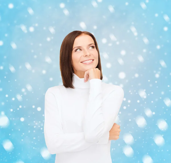 Thinking and smiling woman in white sweater — Stock Photo, Image