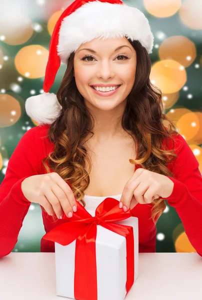 Donna sorridente in cappello Babbo Natale helper con confezione regalo — Foto Stock
