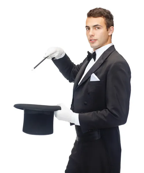 Mágico em chapéu superior com varinha mágica mostrando truque — Fotografia de Stock