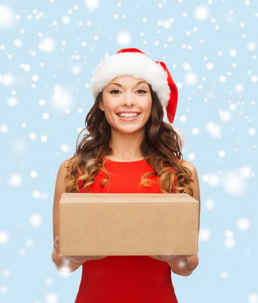 Lachende vrouw in helper kerstmuts met perceel box — Stockfoto