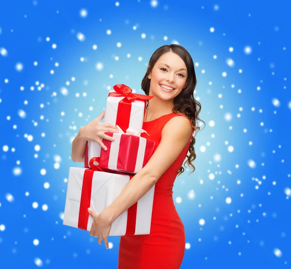 Usmívající se žena v červených šatech s mnoha dárkové krabičky Stock Obrázky