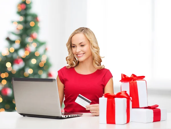 Vrouw met geschenken, laptopcomputer en credit card — Stockfoto