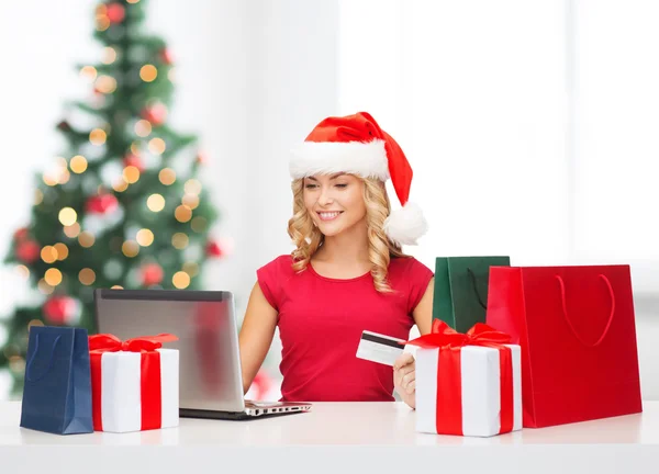 Vrouw met geschenken, laptopcomputer en credit card — Stockfoto