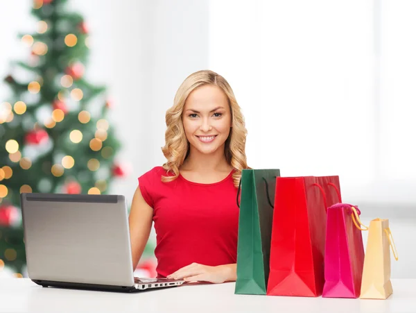 Vrouw met shopping tassen en laptopcomputer — Stockfoto