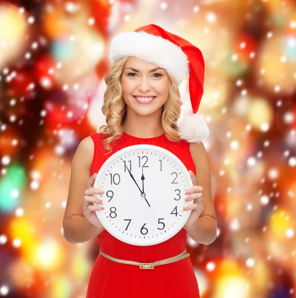 Vrouw in helper kerstmuts met een klok weergegeven: 12 — Stockfoto