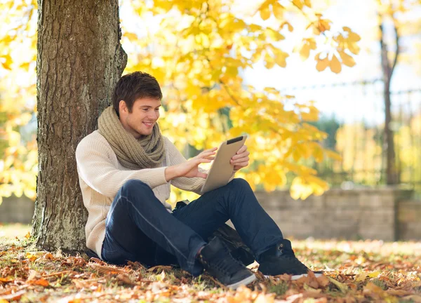 Homem com tablet pc no parque de outono — Fotografia de Stock