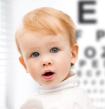 Adorable baby child with eyesight testing board clipart