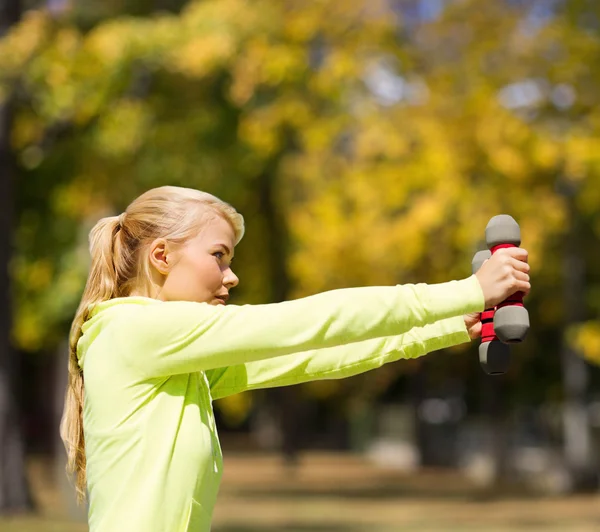 Sportieve vrouw met lichte halters buitenshuis — Stockfoto